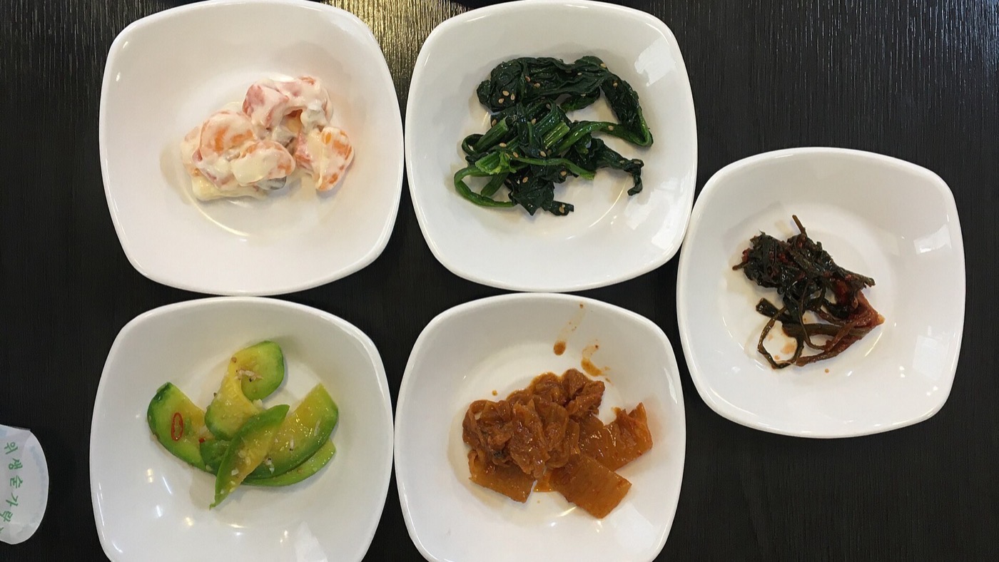 Un menú coreano servido con arroz, sopa y acompañamientos