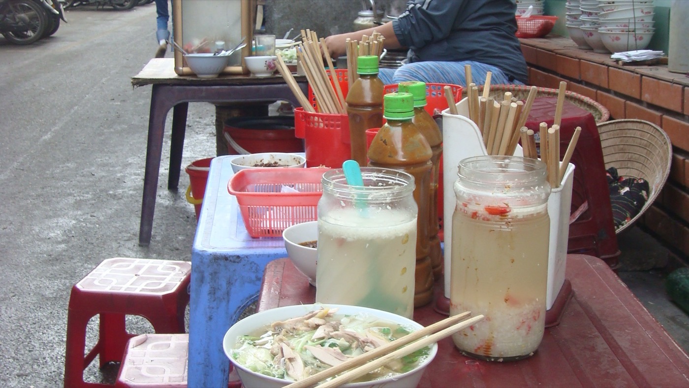 Una vendedora callejera sirviendo phở en Hanói